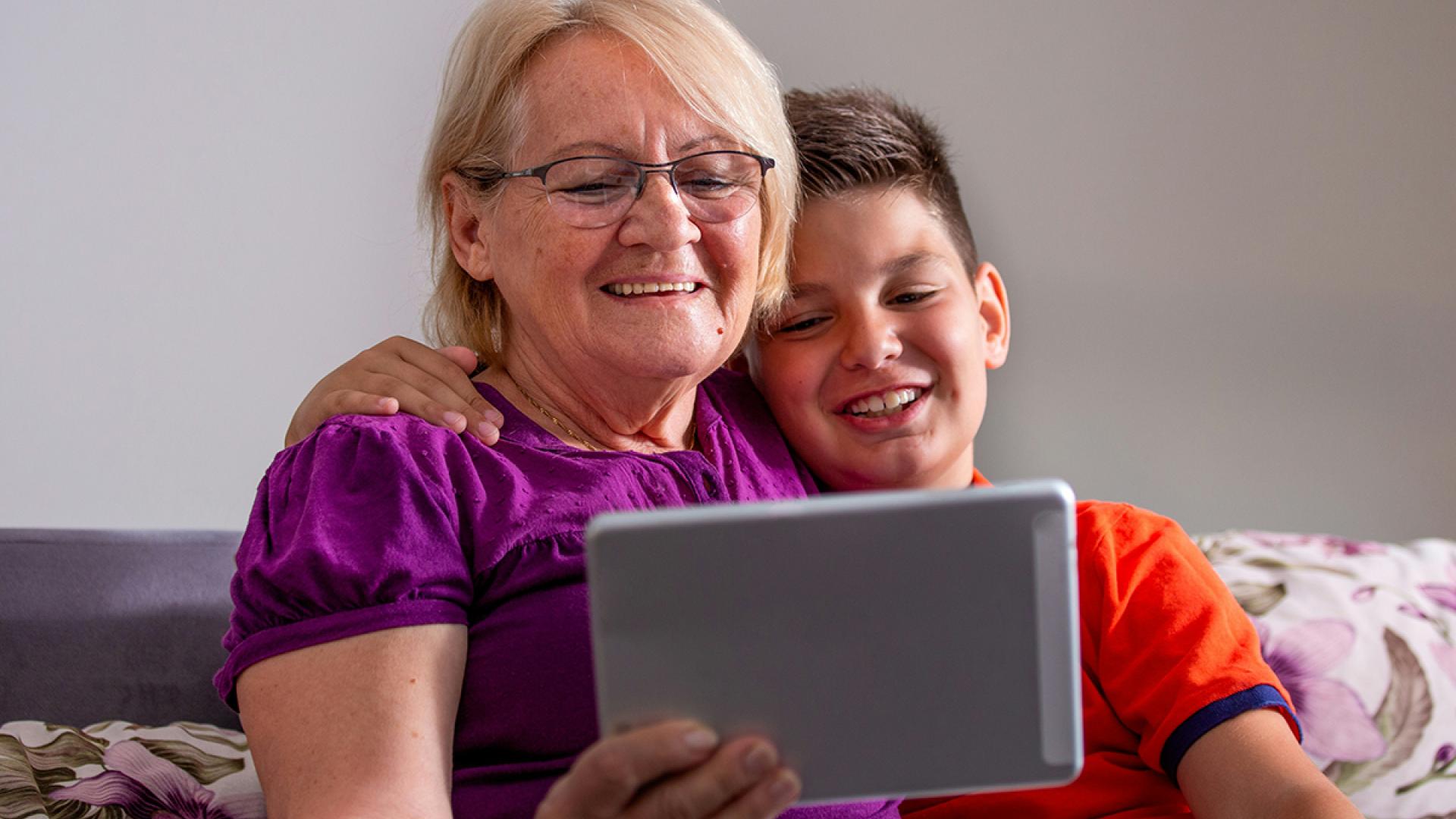 Smiling mom and grandson registering using tablet device